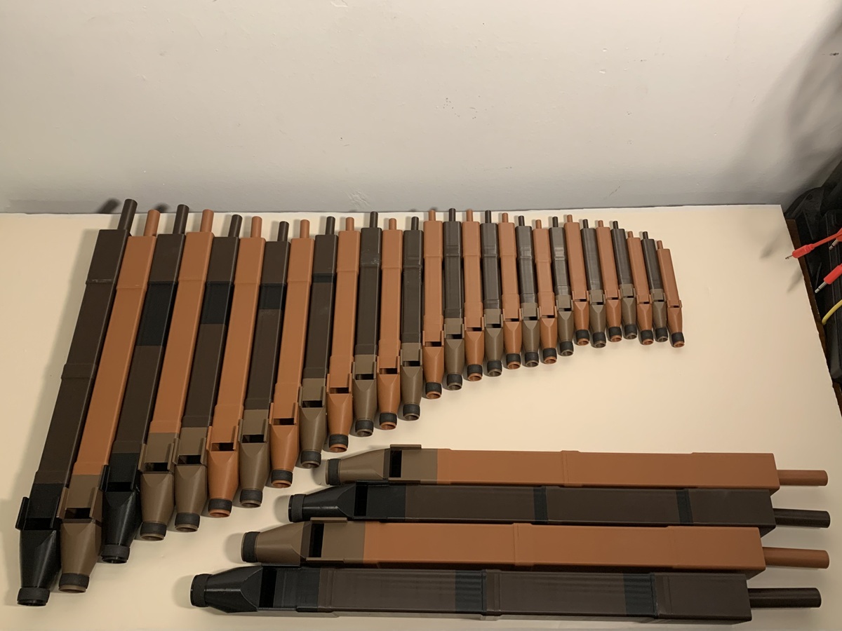 Rows of printed organ pipes laid out on a table, longest to shortest