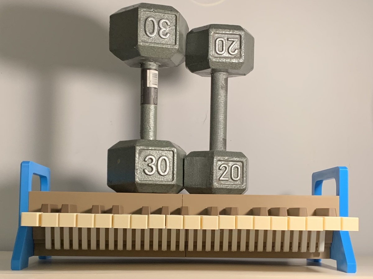 Two dumbbells resting on the keyboard frame