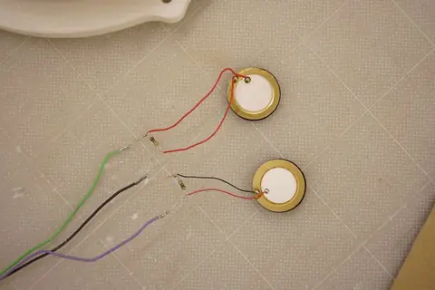 Two piezo discs with red and black wires soldered on