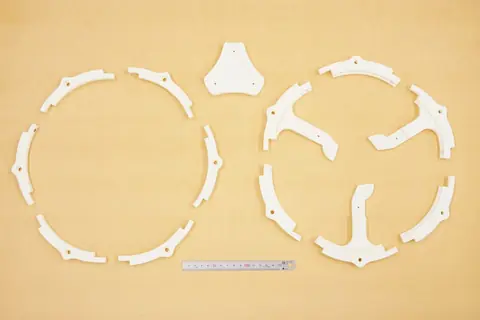 White printed rim segments and bottom frame parts laid out on a table