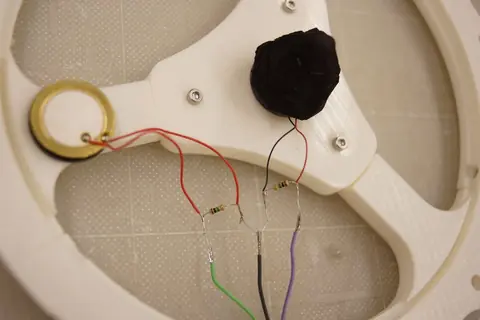 A piezo disc and a black sponge cone mounted on the printed frame